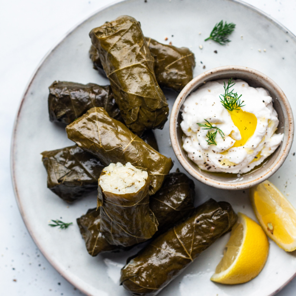 Na zdjęciu znajduje się talerz z greckimi gołąbkami (dolmades).